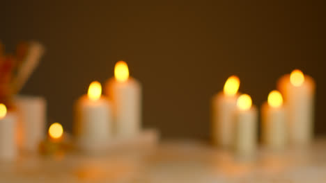 Defocused-Still-Life-Shot-Of-Lit-Candles-With-Dried-Grasses-As-Part-Of-Relaxing-Spa-Day-Decor